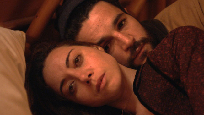 A scene of two people in bed from Black Bear